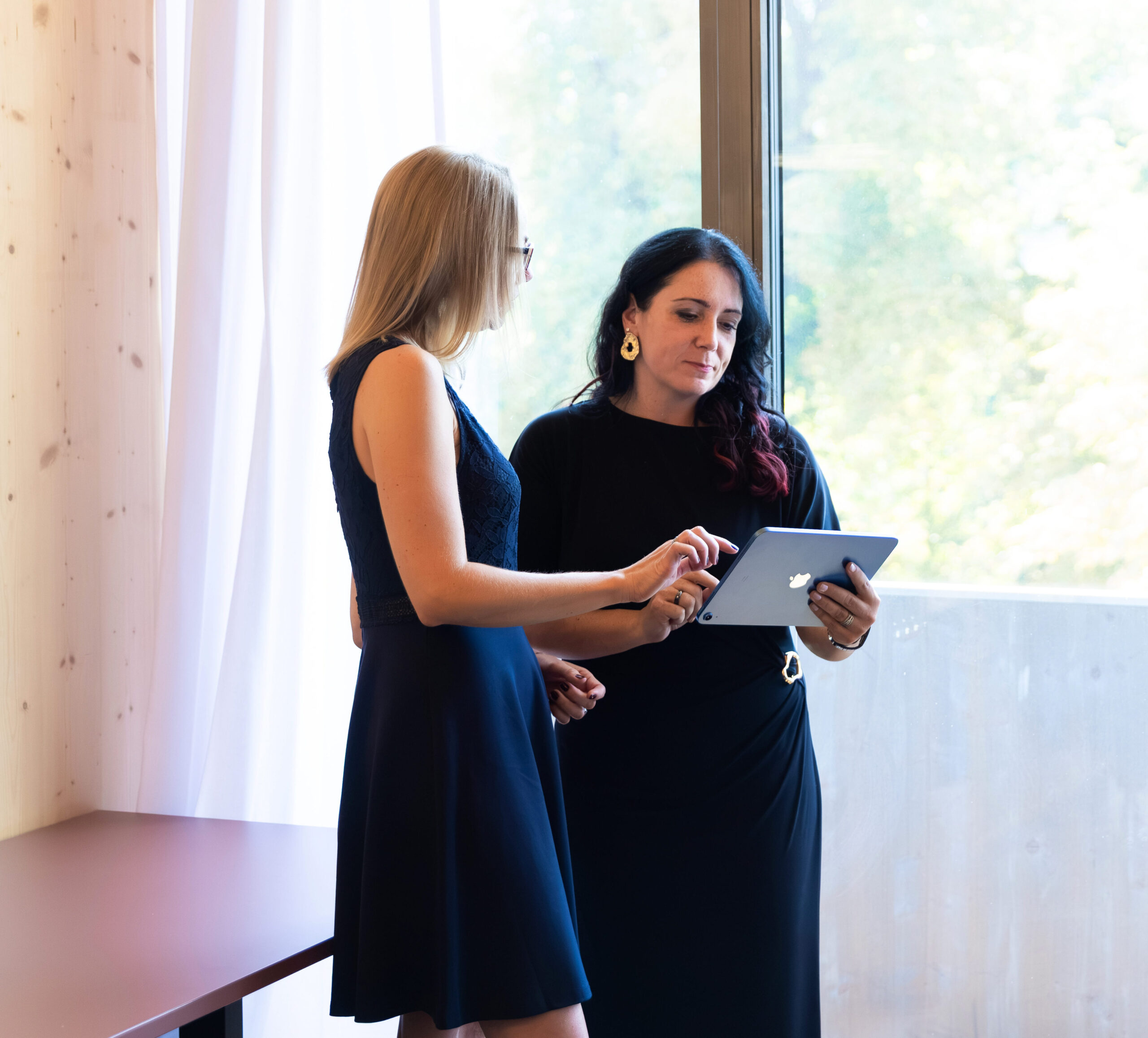 Zwei Frauen besprechen Ergebnisse auf einem Tablet