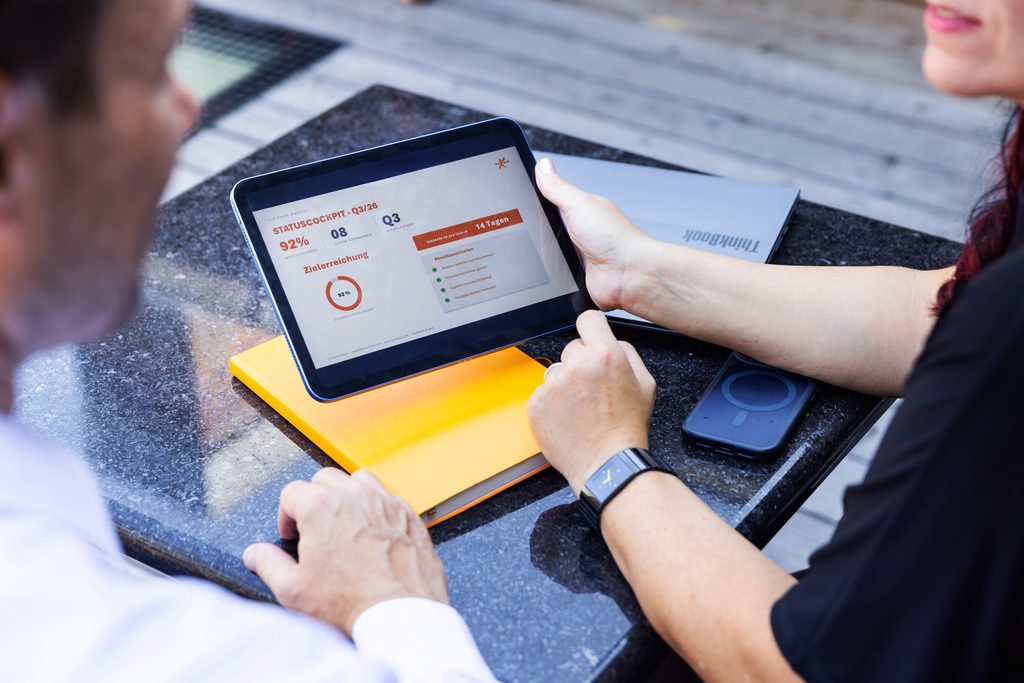 Zwei Personen besprechen Ergebnis am Tablet